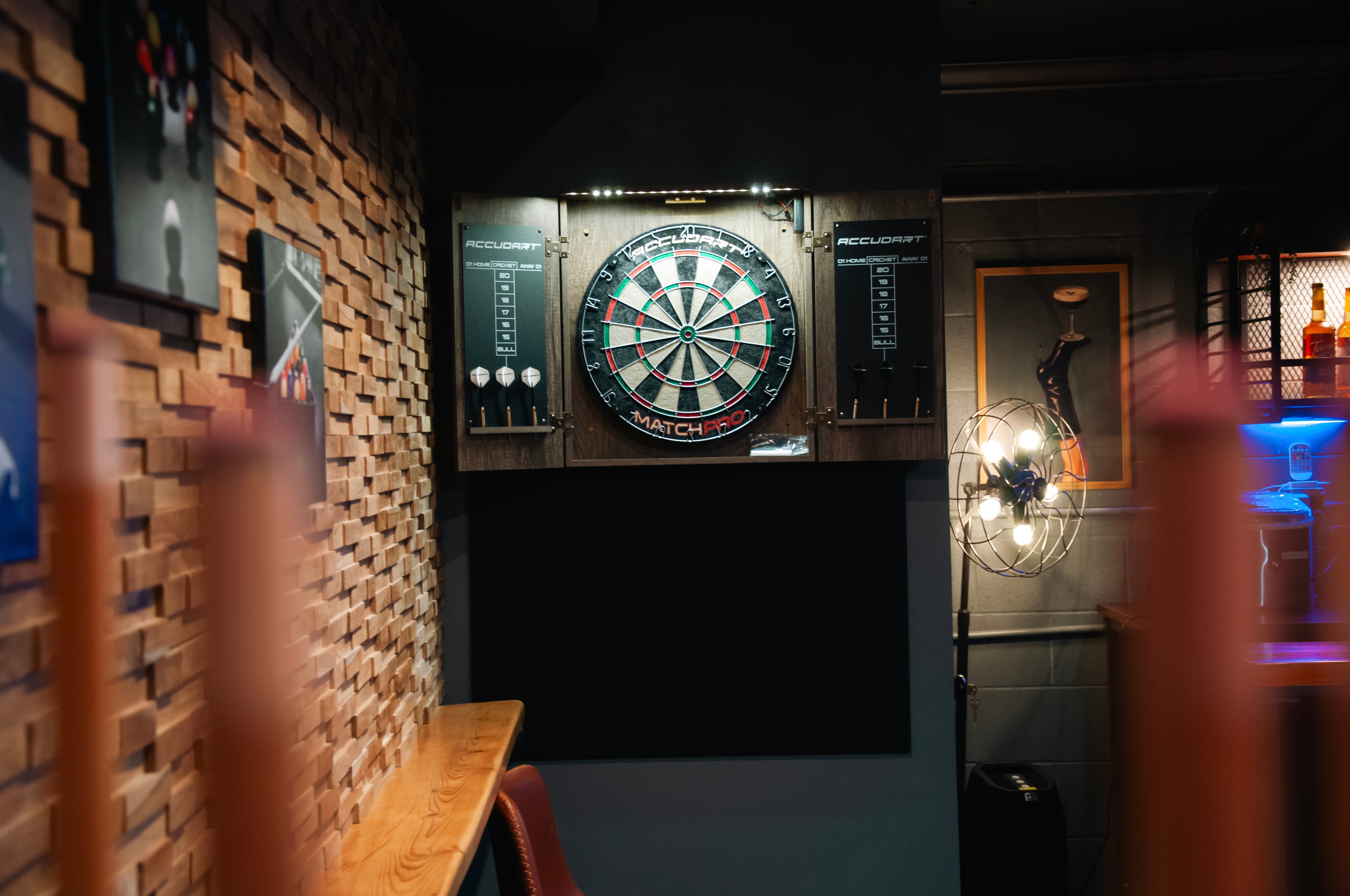 Game Room — dartboard cabinet with bar and blue ambient lighting