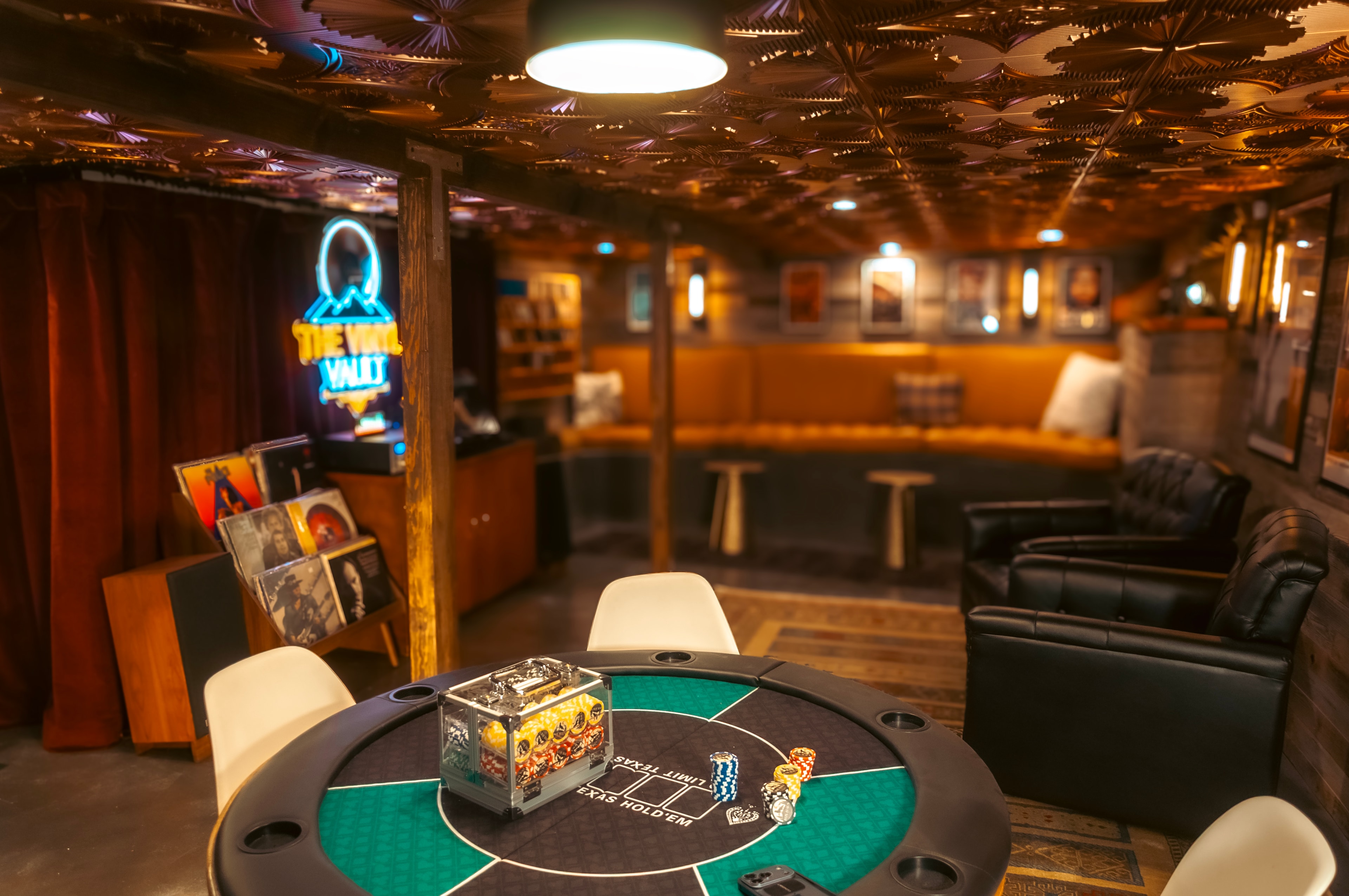 Game Room — poker table with chips in foreground, Vinyl Vault visible beyond