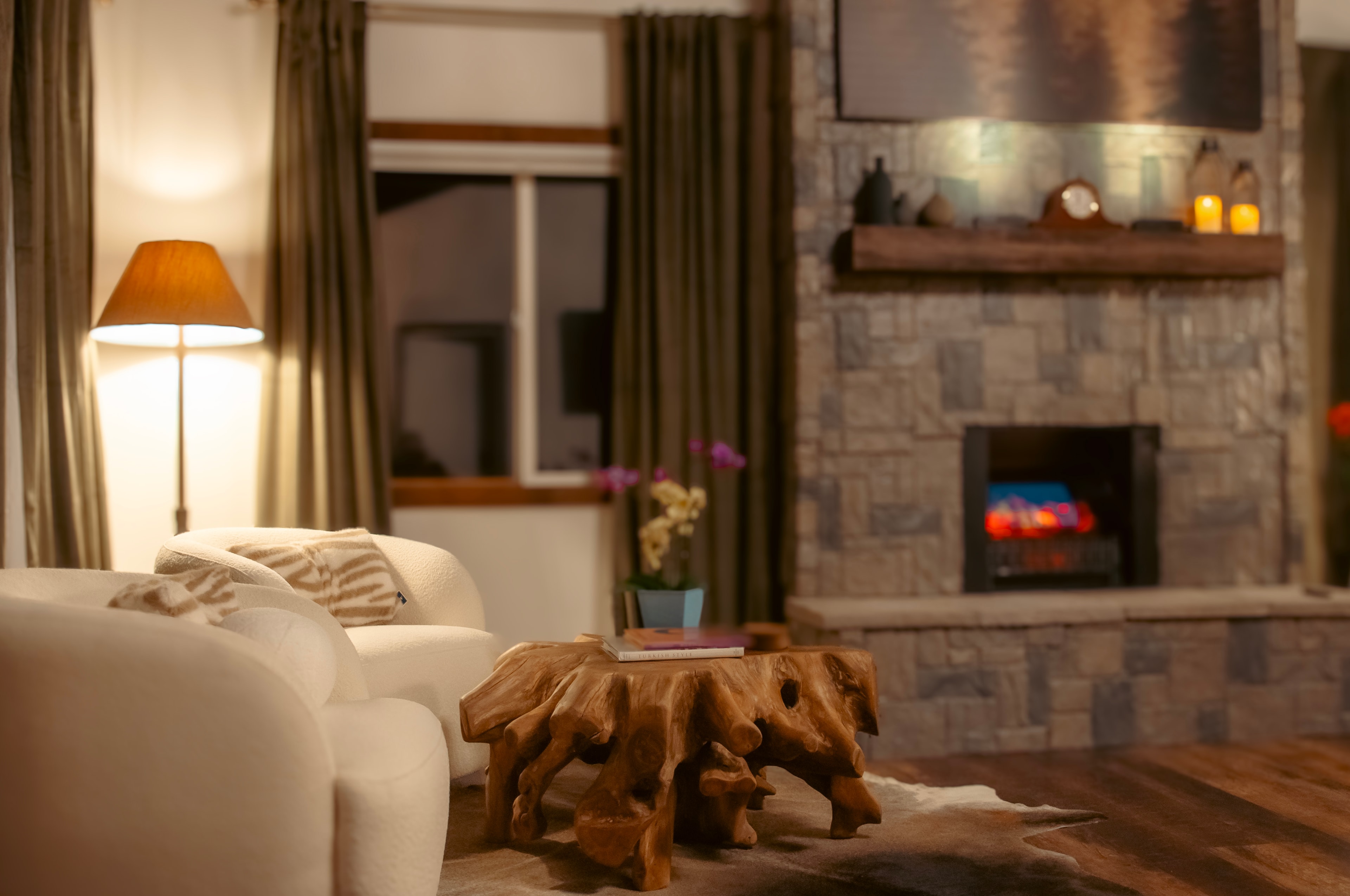 Master Suite — boucle sitting chairs with live-edge coffee table and stone fireplace