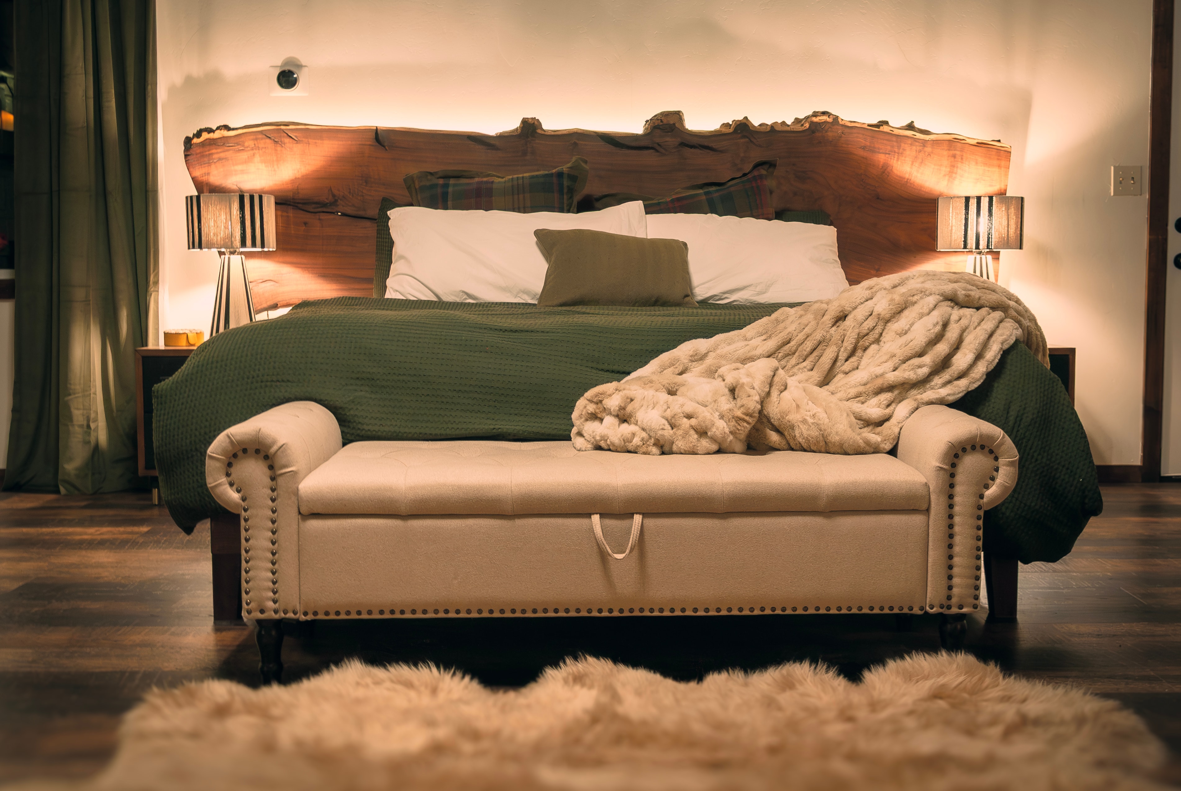 Master Suite — custom Black Walnut live-edge headboard with integrated lighting and fur throw
